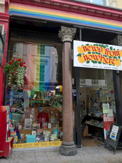 The vibrant outside of News from Nowhere, Liverpool's radical and community bookshop, adorned with a rainbow flag and colourful window display.