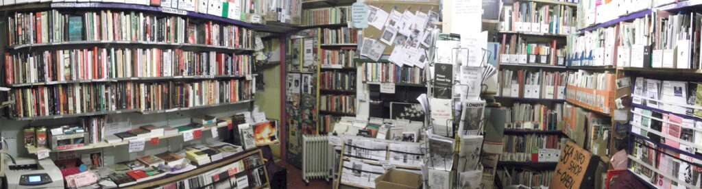 The interior of 56a Infoshop in London, filled with shelves of books, pamphlets, and zines on radical and activist topics. The space is densely packed with literature and community resources. © 56a Infoshop
